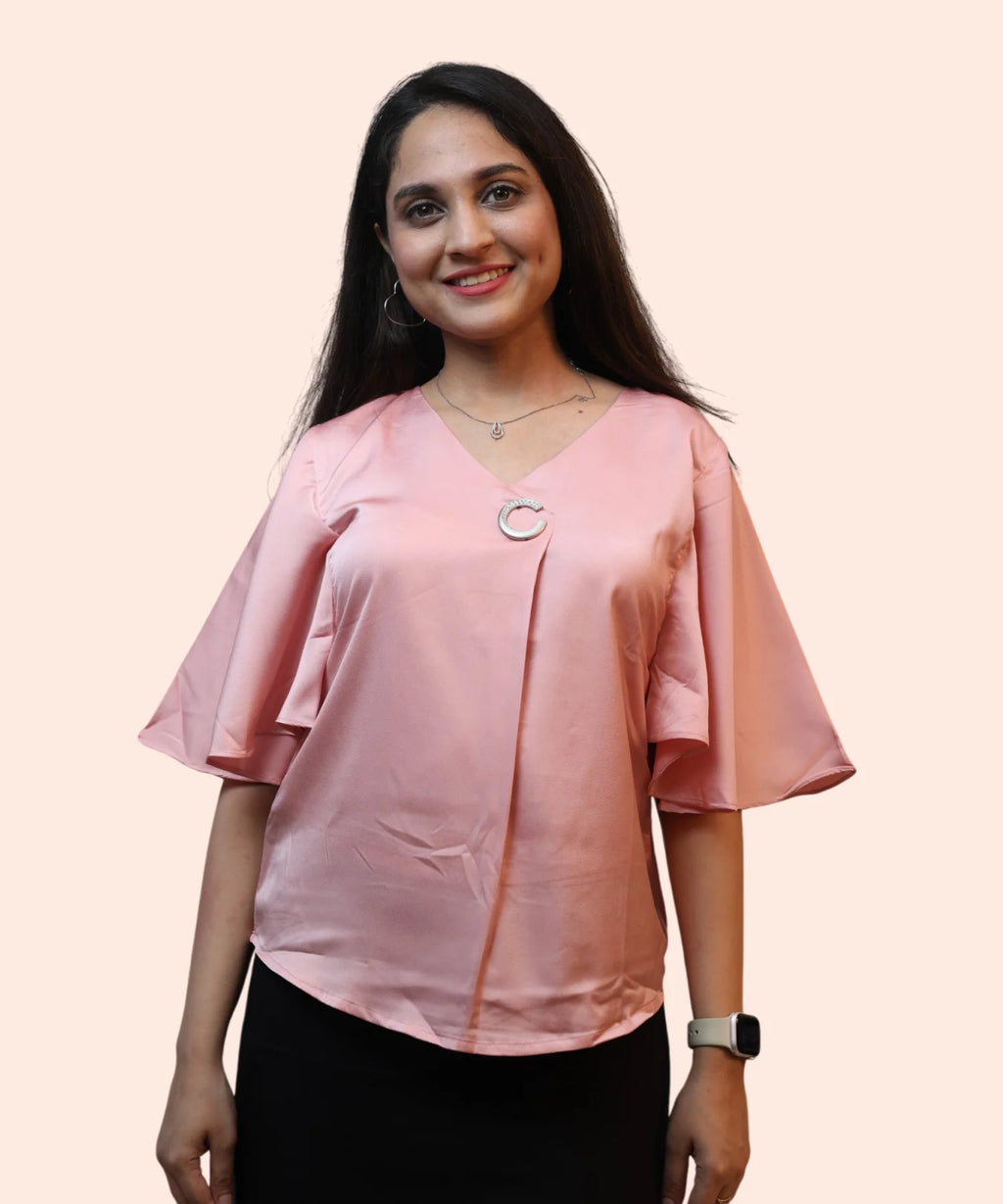 Close-up women's baby pink satin cape sleeve top V-neck and silver brooch detail workwear blouse Ladymade