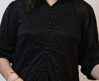 Upper body close-up puff sleeve and pearl buttons on women's black schiffli lace workwear shirt Ladymade