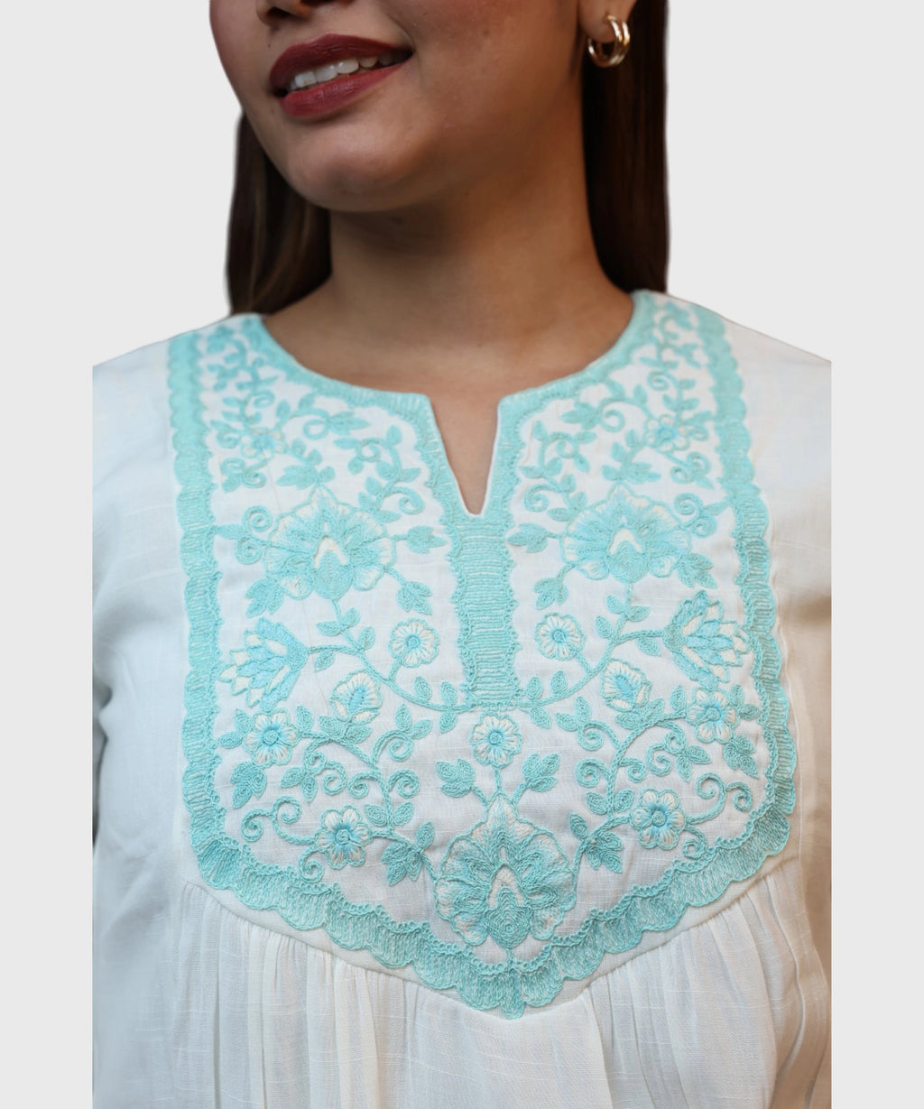 Extreme close-up turquoise floral embroidery scalloped border craftsmanship white cotton kurti top Ladymade