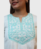 Extreme close-up turquoise floral embroidery scalloped border craftsmanship white cotton kurti top Ladymade