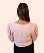 Full back profile view showing the comfortable regular fit and stretch of a baby pink ribbed evening wear blouse by Ladymade.