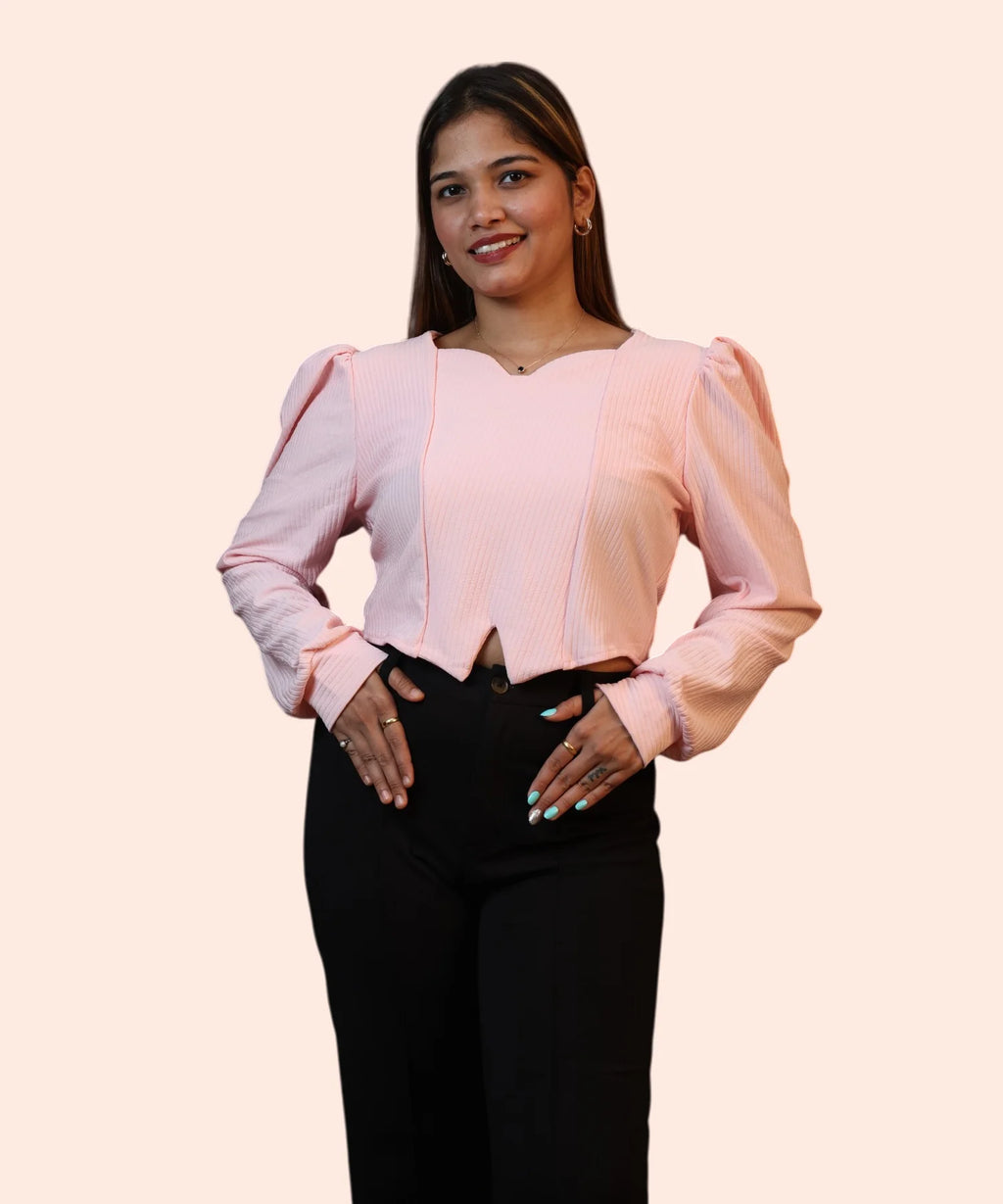 Symmetrical front studio view of a woman posing in a structured baby pink ribbed puff sleeve workwear blouse by Ladymade.
