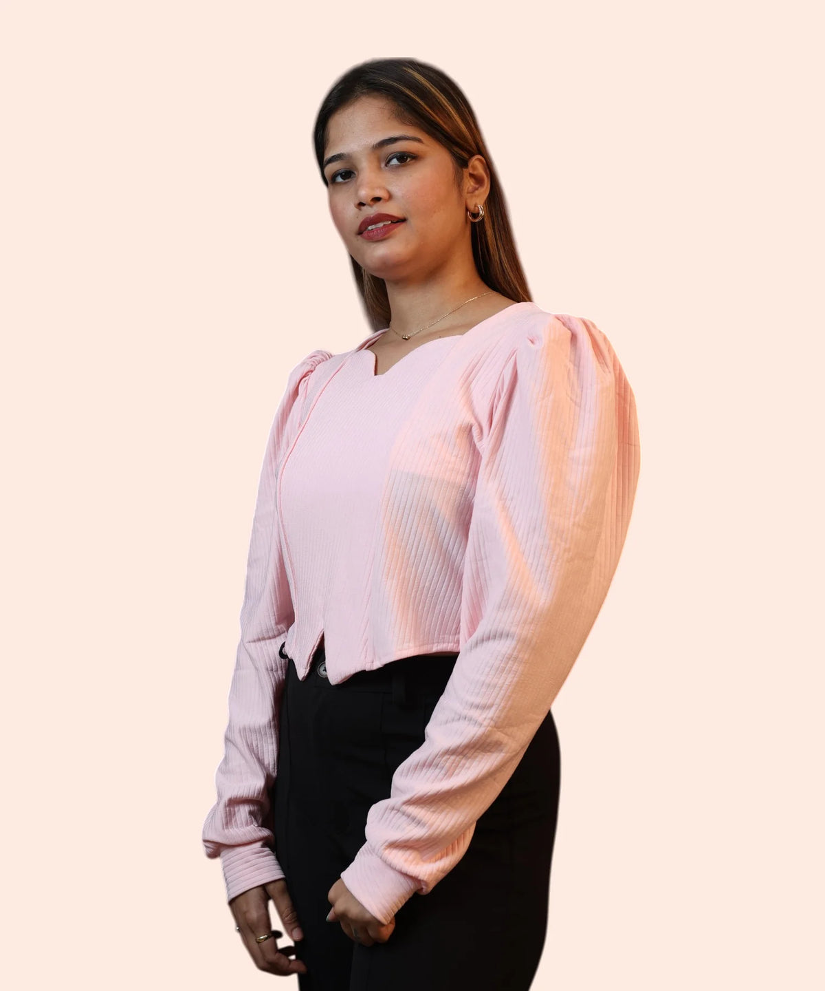 Side View corporate portrait showing a woman modelling a baby pink ribbed office top with black trousers by Ladymade.