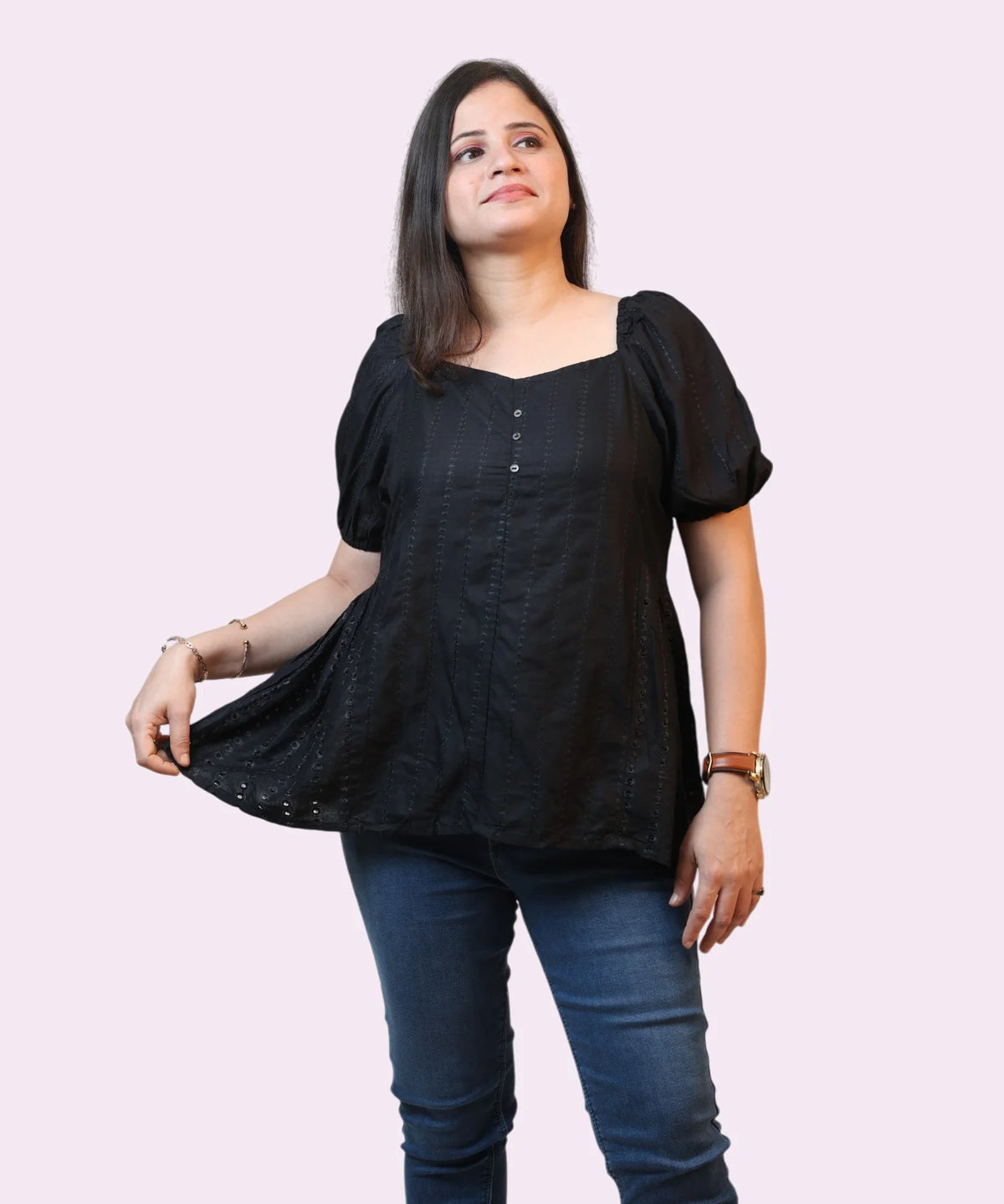 A three-quarter candid studio view of a woman showcasing the regular fit of an embroidered black peplum office blouse by Ladymade.