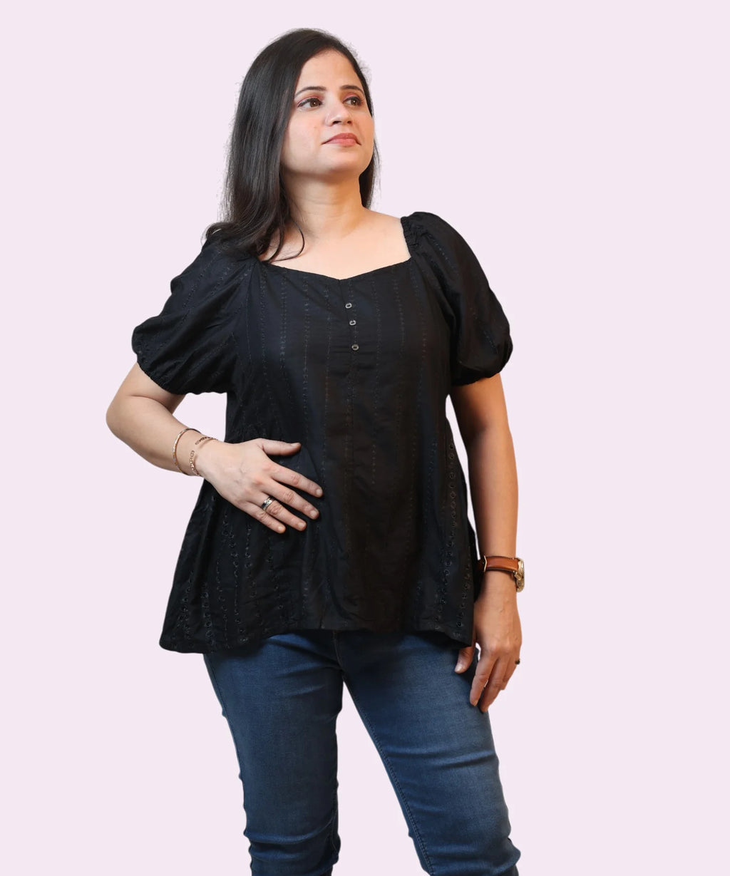 Mid-shot view highlighting the elegant sweetheart neckline and buttoned placket on a black schiffli formal top by Ladymade.