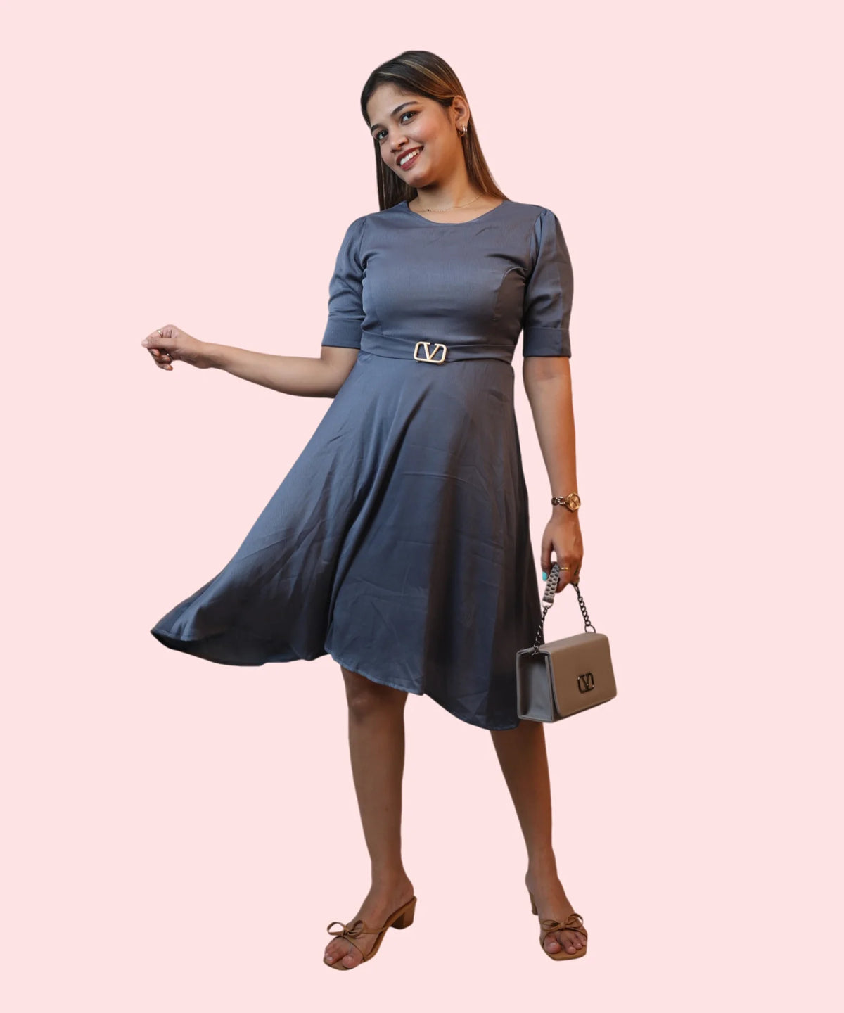 Full-length shot of a woman displaying the fluid A-line skirt drape of a steel grey formal dress by Ladymade.