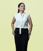 Three-quarter studio portrait of a woman posing in a sleeveless ivory tie-neck office blouse by Ladymade.