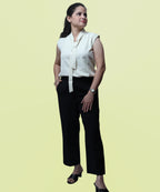 Full-length corporate fashion look featuring an ivory sleeveless polycotton blouse with black trousers by Ladymade.