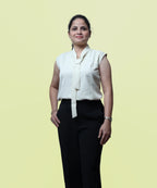 Front view profile of a woman modeling a premium ivory sleeveless tie-neck workwear blouse by Ladymade.