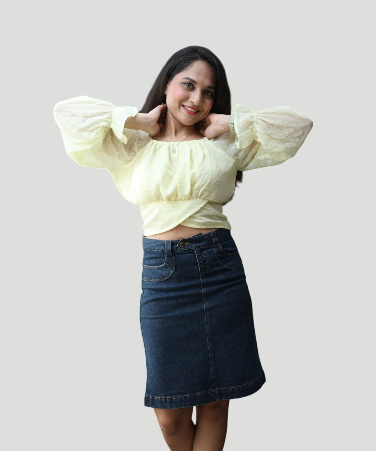 Three-quarter candid photo of a woman wearing an elegant lemon yellow clip-dot chiffon top by Ladymade.