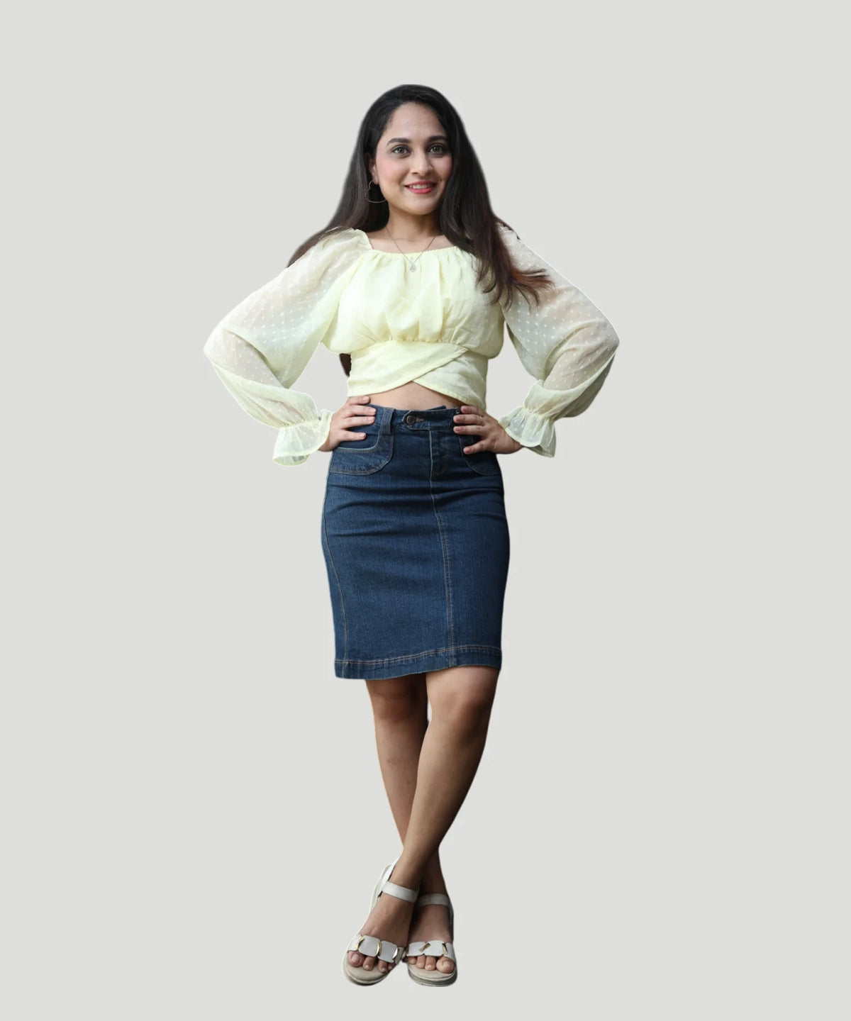 Full-length studio portrait of a woman styling a lemon yellow chiffon crop top with a dark denim skirt by Ladymade.