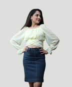 Detailed view highlighting the cross-over wrap hem and puff sleeves on a lemon yellow chiffon blouse by Ladymade.