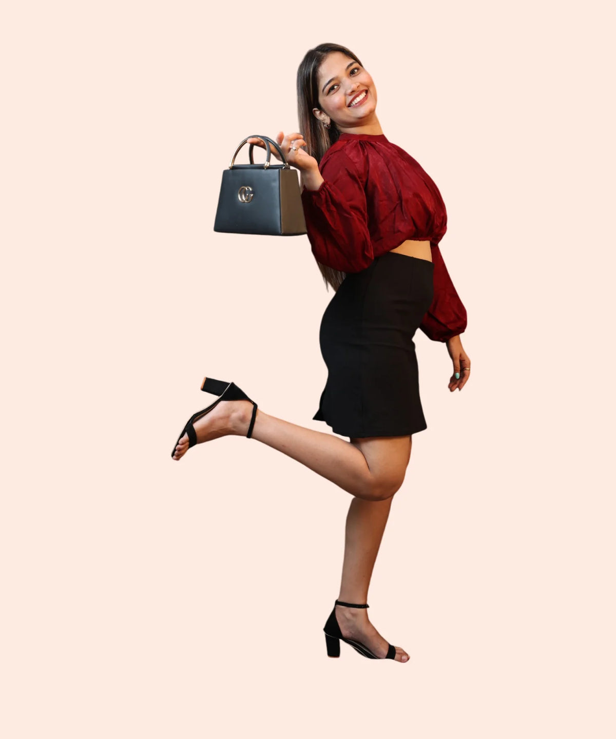 Dynamic lifestyle view of a woman smiling and holding a purse in a maroon velvet evening wear crop top by Ladymade.