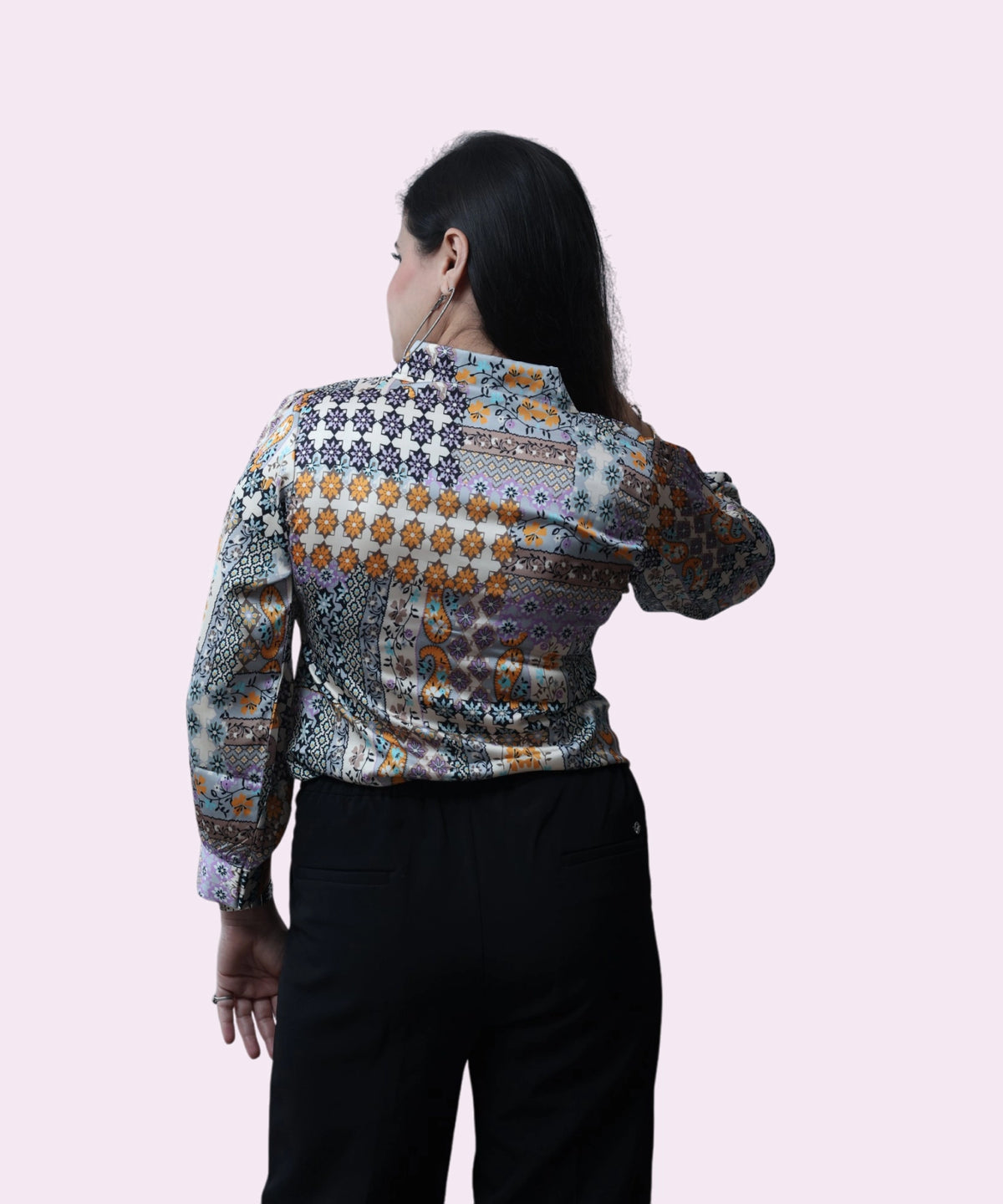 Back view of a women's satin workwear blouse showing the detailed multi-color geo-tribal print by Ladymade.