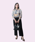 Full-length front shot of a woman in a printed satin office top paired with black trousers by Ladymade.