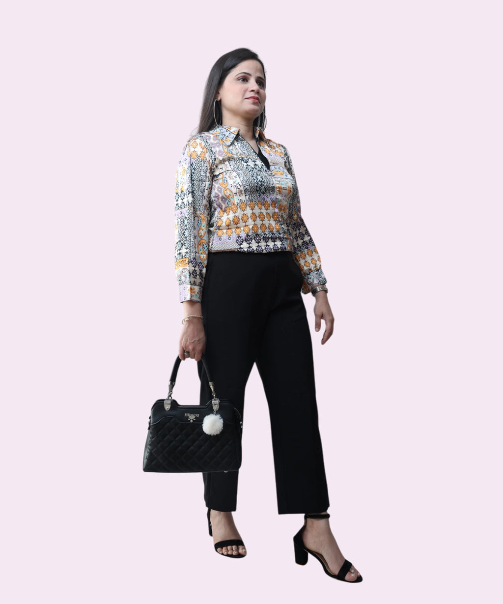 A professional office look featuring a multi-colored satin tribal print top and black wide-leg trousers by Ladymade.