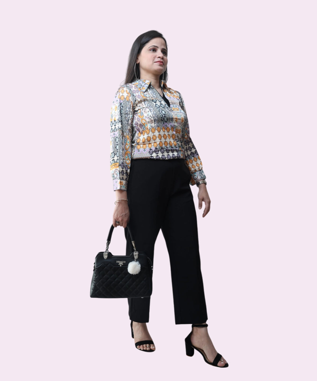 A professional office look featuring a multi-colored satin tribal print top and black wide-leg trousers by Ladymade.