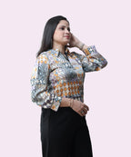 Side view of a woman wearing a multi-color geo-tribal print satin workwear blouse by Ladymade.