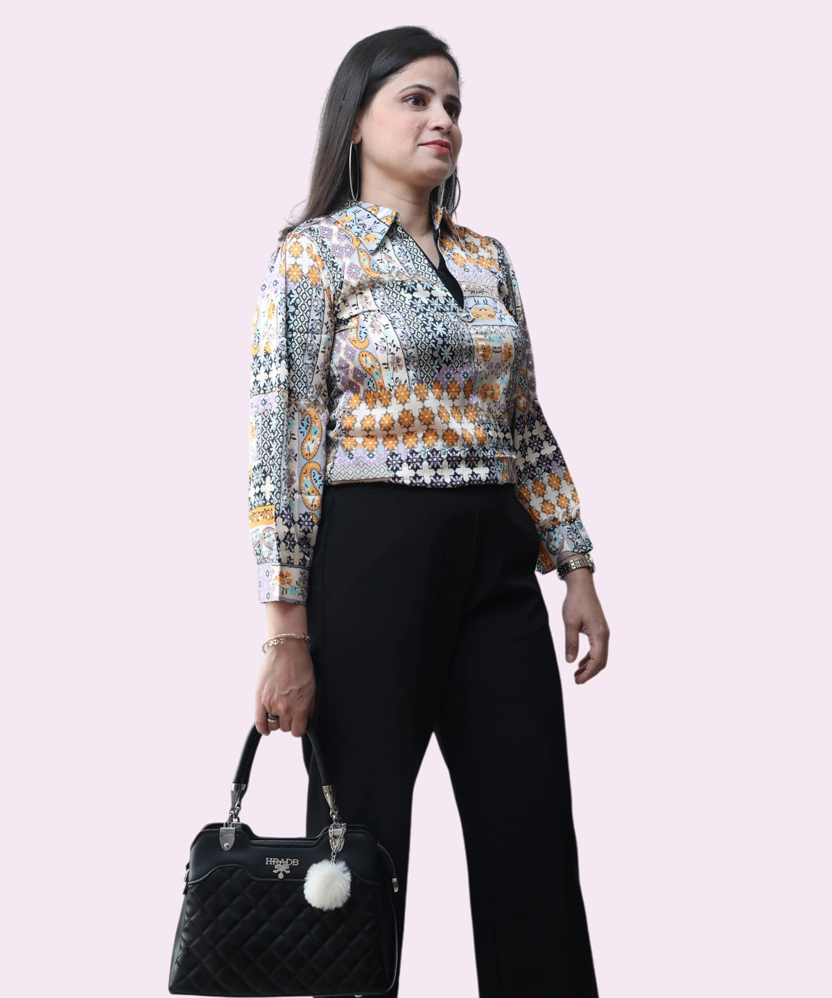 Professional lifestyle shot of a woman wearing a multi-colored satin formal top for office and evening wear by Ladymade.