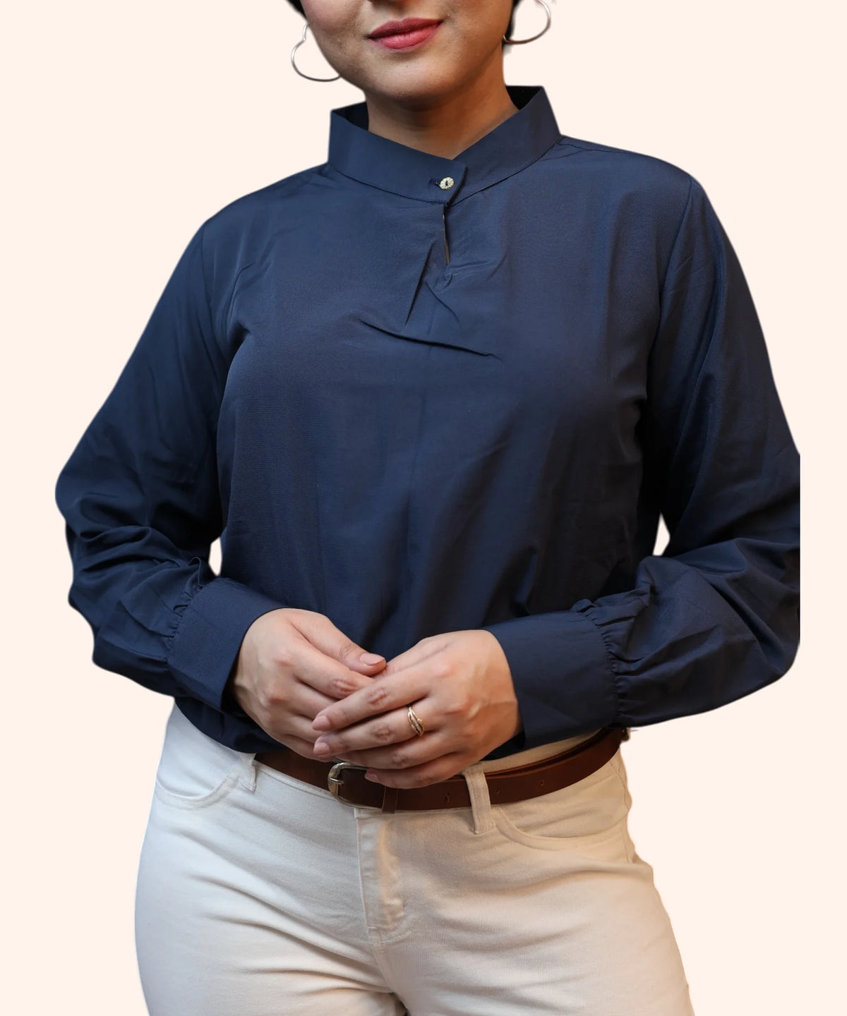 Mid-shot view highlighting the clean pleated front and cuffed long sleeves of a navy blue polycotton office blouse by Ladymade.