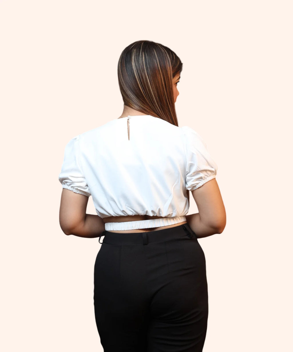 Close-up back view showing the keyhole button closure and elasticated lower band of an off-white formal top by Ladymade.