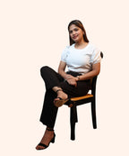 Alternate cross-legged sitting view displaying the waist proportions of an off-white puff sleeve office top by Ladymade.