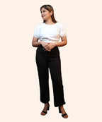 Full-length front view of a woman posing in an off-white puff sleeve crop top with a smocked hem by Ladymade.