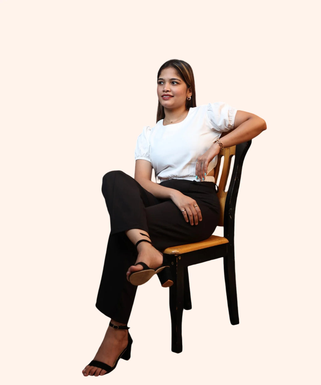 Studio portrait of a woman looking away while wearing an off-white round neck puff sleeve crop top by Ladymade.