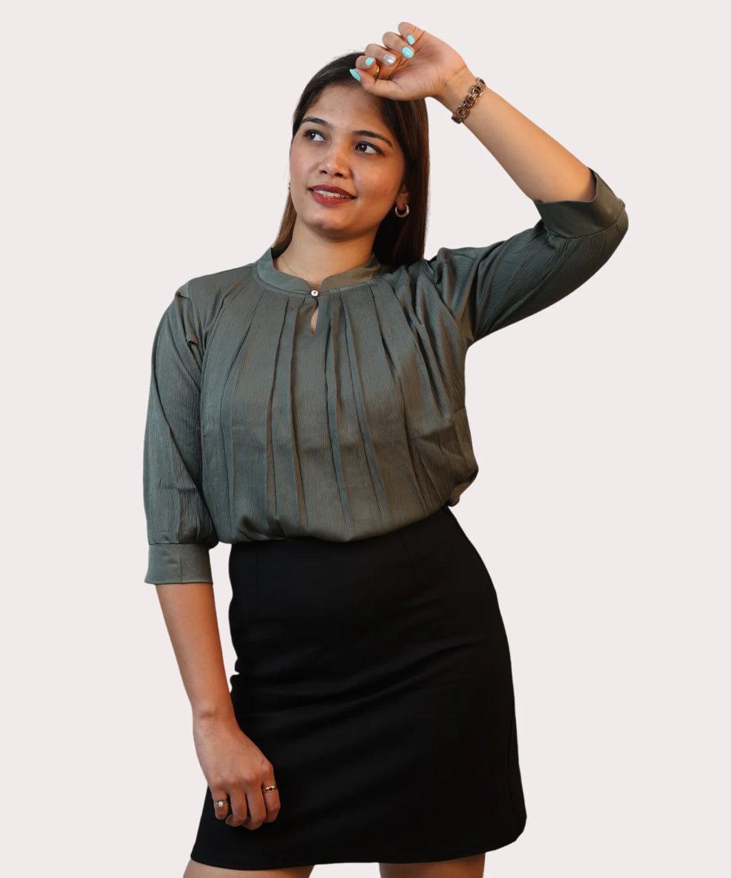 Lifestyle studio frame capturing a woman looking away in a puff sleeve olive green corporate top by Ladymade.