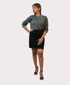 Full-length front view of a woman posing in an olive green crepe pintuck top with a keyhole neck by Ladymade.