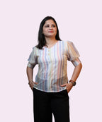 Front view women's pastel viscose stripe puff sleeve top hands in pockets black trousers Ladymade