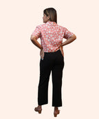 Full back profile view showcasing the clean hemline of a women's peach pink daisy crop top by Ladymade.
