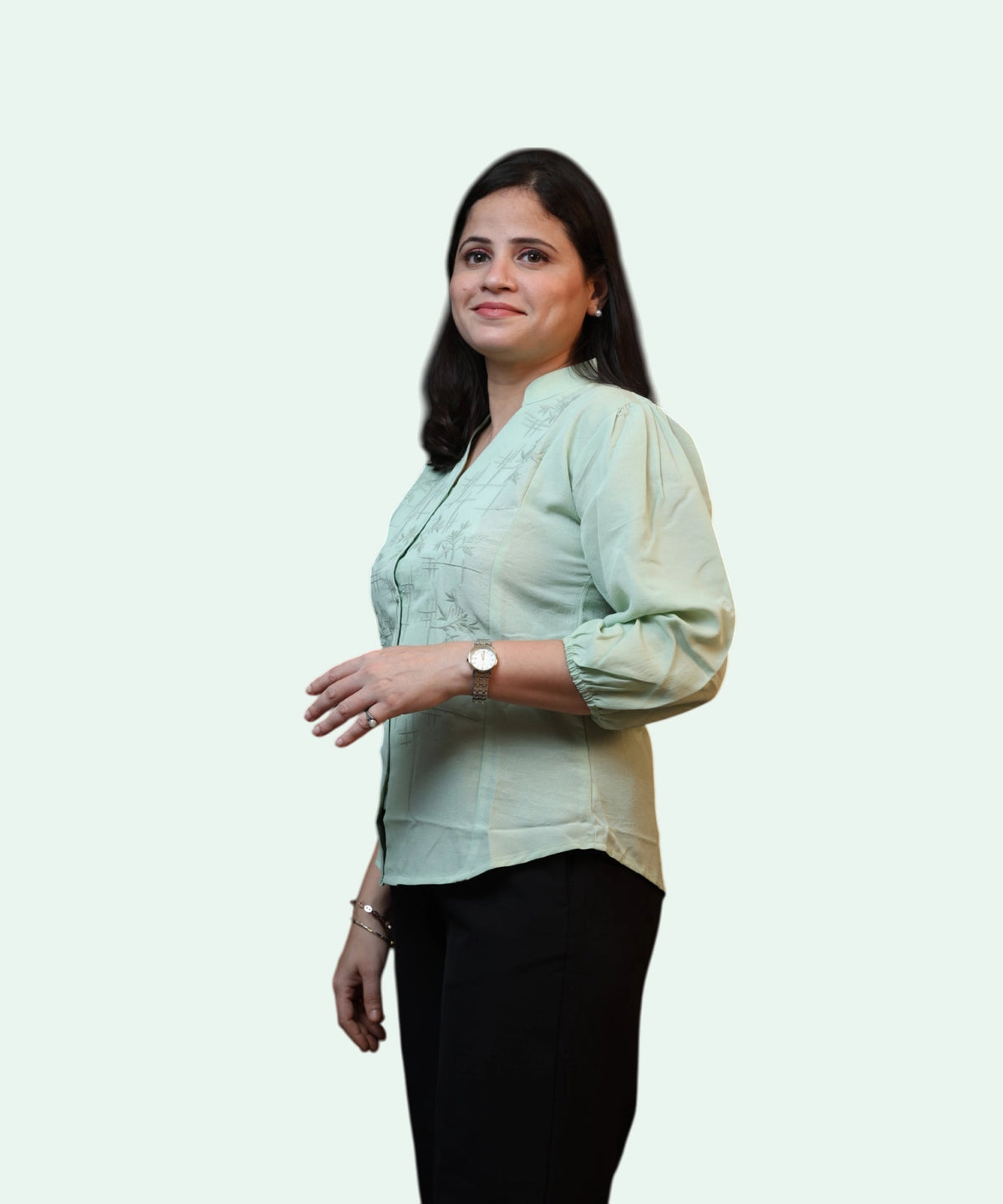 Side view of a professional woman posing in a light pista green embroidered cotton formal blouse by Ladymade.