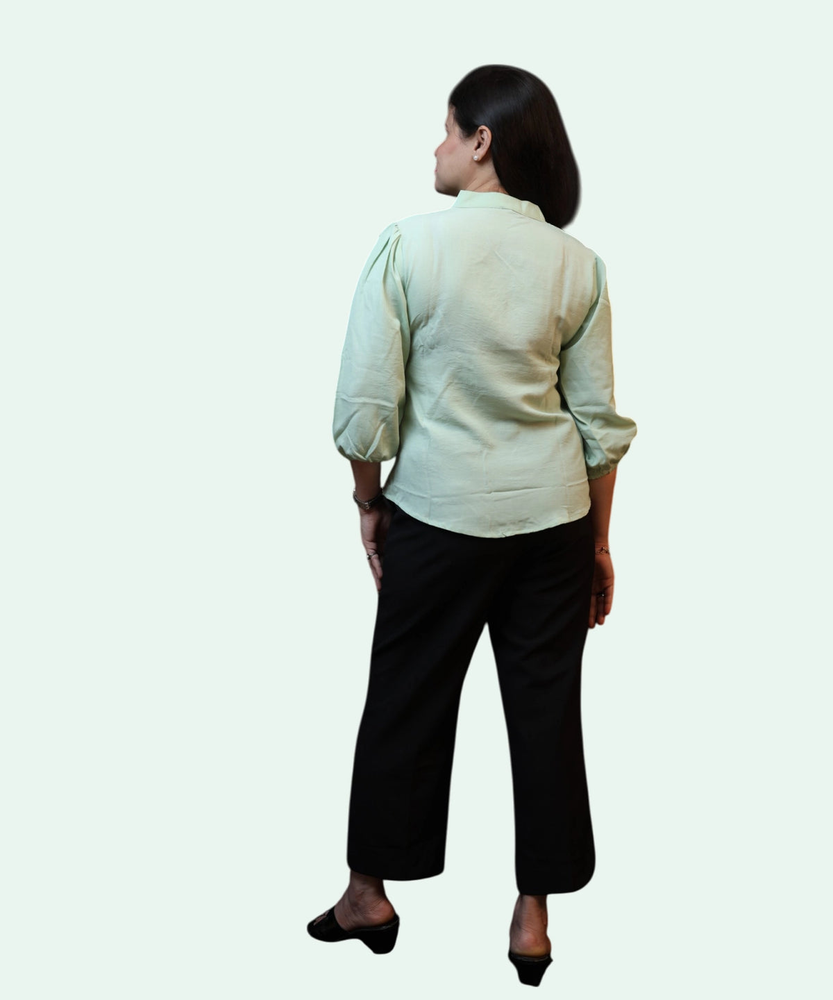Full back shot showing the regular fit and gathered sleeve cuffs of a pista green cotton formal blouse by Ladymade.
