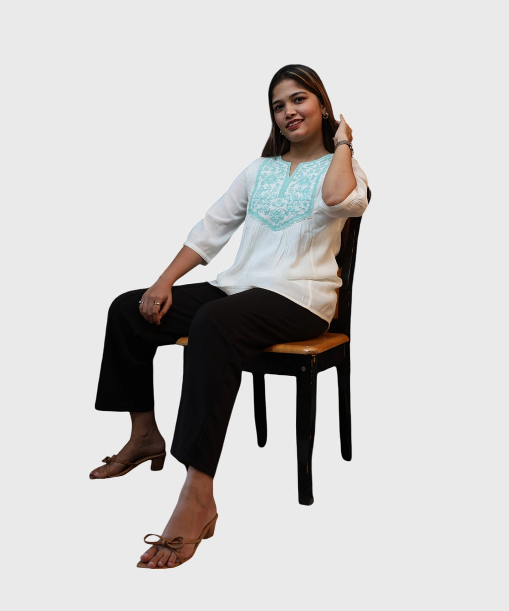 Women's white cotton kurti top turquoise embroidered yoke relaxed seated office pose black trousers Ladymade