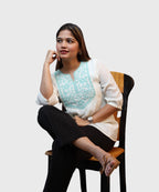 Women's white cotton kurti top turquoise embroidered yoke seated pose black trousers workwear Ladymade