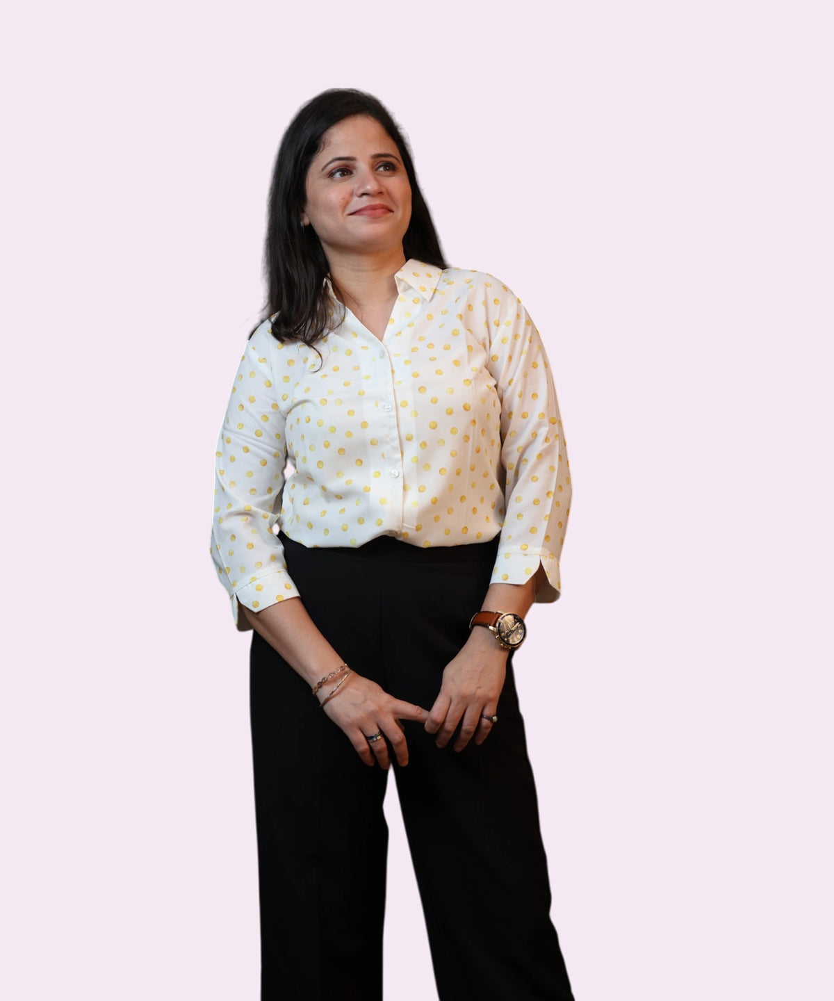 A woman in a sun-kissed yellow polka dot cotton blend shirt looking sideways, professional workwear by Ladymade.