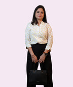 Full front view of a woman wearing a white and yellow polka dot formal button-down shirt by Ladymade.